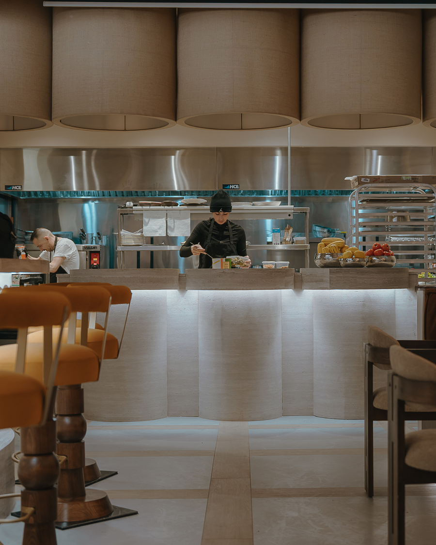 Comptoir courbé du restaurant Cococina habillé du panneau flexible travertino beige BétonFlex | Artmur Montréal