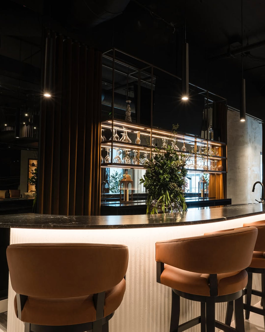 Fauteuils du lounge face au bar du Salon exécutif MVP, façade en panneau flexible Ripple BétonFlex | Artmur