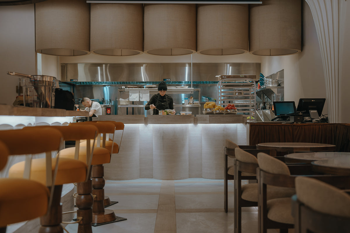 Salle du restaurant Cococina, comptoir effet travertin BétonFlex et chaises en bois | Artmur Montréal
