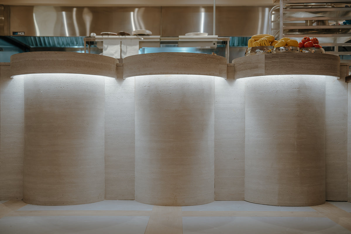 Close view of Cococina's wavy counter in travertine-look BétonFlex flexible panel under grazing light | Artmur