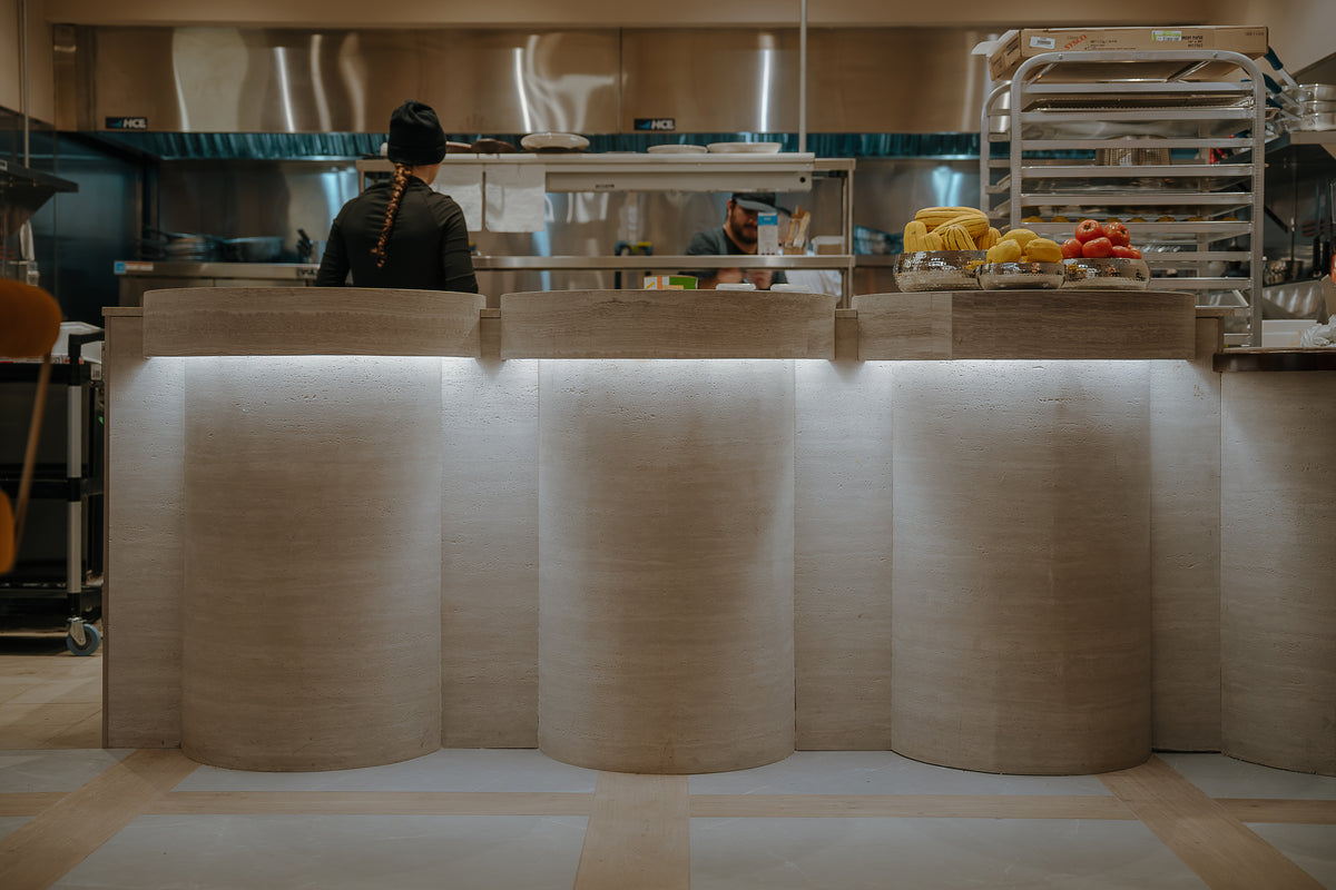 Cuisine ouverte de Cococina derrière le comptoir en panneau flexible travertino BétonFlex | Artmur Montréal