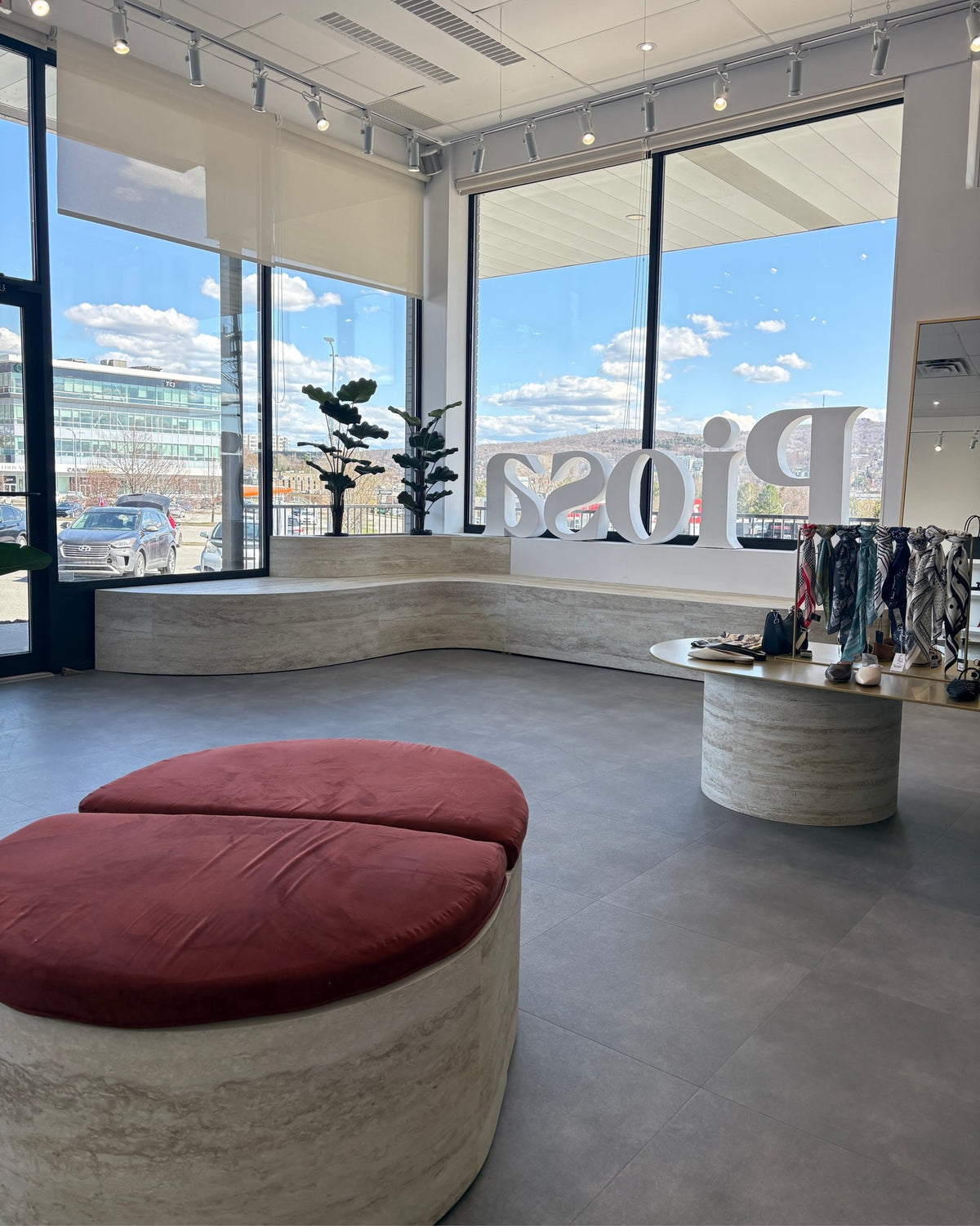 Vitrine de la boutique Piosa : banc courbe et pouf habillés du panneau flexible effet travertin BétonFlex
