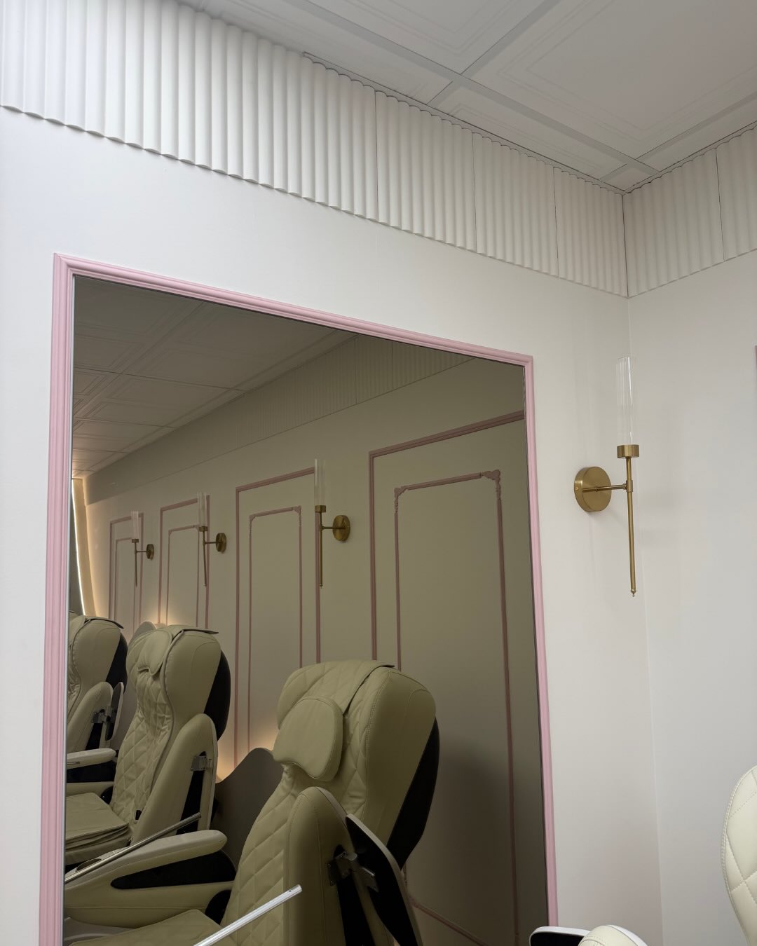 Espace pédicure du studio NailBbox avec encadrement rose et murs moulurés