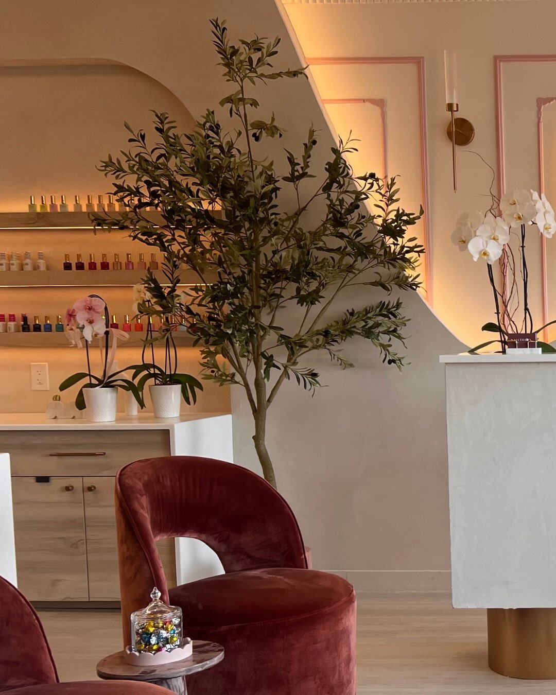Espace d'attente du studio NailBbox avec fauteuils en velours et murs aux arches arrondies