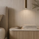 Bedroom with a Yunshan beige grey travertine-look BétonFlex flexible wall panel and a natural oak slat nightstand