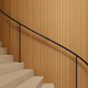 Curved staircase wall covered in the natural oak Mini slat SuperFlex flexible panel