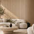 Living room with a curved wall covered in the natural oak Mini slat SuperFlex flexible panel