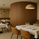 Restaurant dining room with a rounded wall in the walnut Mini slat SuperFlex flexible panel
