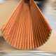 Panneau flexible Velour Rouille foncé VelvFlex courbé en éventail, démonstration de sa flexibilité